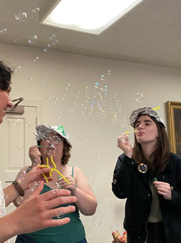 Alex Angelini (left) and Lyn Bailey (right) pelt Emma De Noble (far left) with bubbles.
